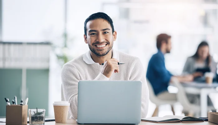 smiling man behind a computer smiling man behind a computer
